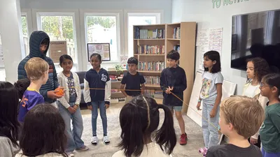 Children working together at a table in Discovery Studio
